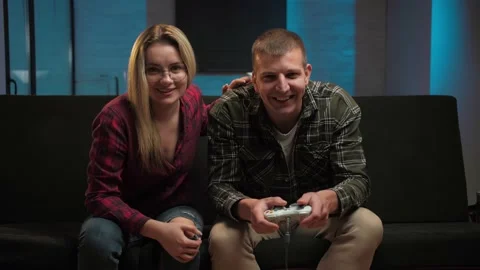 Man playing video games while his girl support him in their living room.Young Stockbeeldmateriaal 225653363