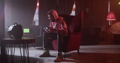 Man playing videogame in dark cafe Stock Footage 229483696