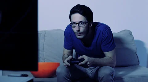 Man Playing Videogames with Gamepad while eating popcorn Stock Footage 32962220