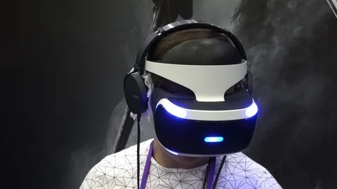 Man playing virtual reality game in Sony VR headset with accessories controllers Stock Footage 83220768