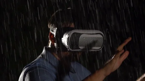 Man playing virtual reality games in the rain. 360 VR technology. Close up. Stock Footage 80307437