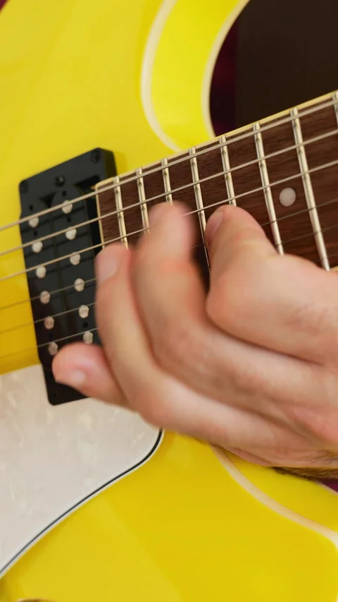 Man playing a yellow guitar, selective focus. No faces shown, vertical video Stock Footage 217730291
