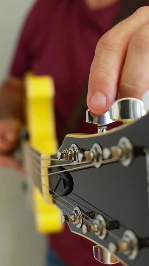 Man playing a yellow guitar, selective focus. No faces shown, vertical video Stock Footage 217730343