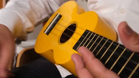 Man playing yellow ukulele Stock Footage 208881560