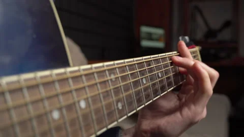 Man Plays an Acoustic Guitar While Sitting on a Couch Stock Footage 171373468
