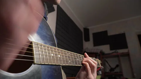 Man Plays an Acoustic Guitar While Sitting on a Couch Stock Footage 171664601