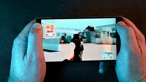 Man plays action video game on his mobile phone at home at night Stock Footage 101078138