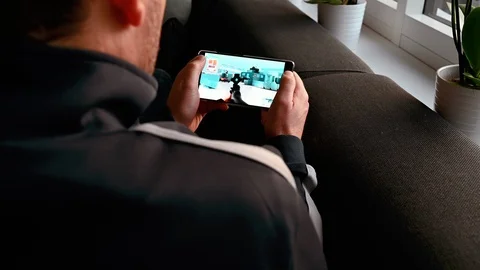 Man plays action video game on his smart phone Stock Footage 101079758