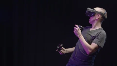 Man plays Action VR in Slow Motion on Black background 스톡 동영상 118602590