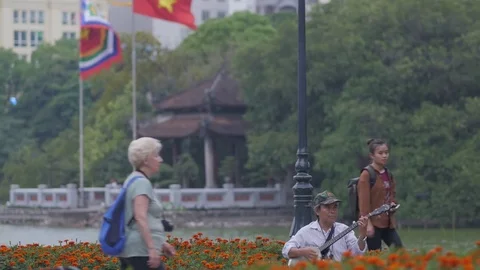 Man plays banjo and Ngoc Son temple,Hanoi,Vietnam Stock Footage