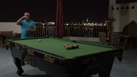 A man plays billiards. The man breaks the pyramid cue ball Stock Footage 100868566