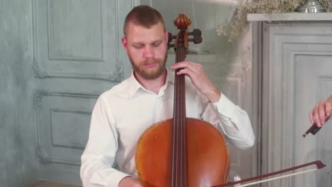 A man plays a bow on cello in the Studio. Panorama from a man to his hands Stock Footage 133752955
