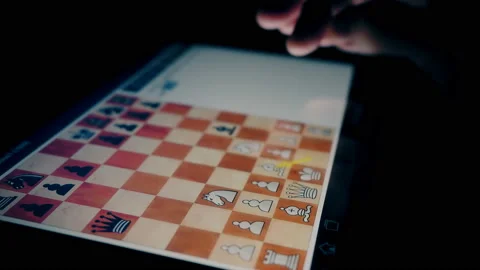 A man plays chess on a tablet at night Stock Footage 154681642