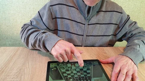 A man plays chess on a tablet. Online chess game. The game on the tablet. Stock Footage 101736748