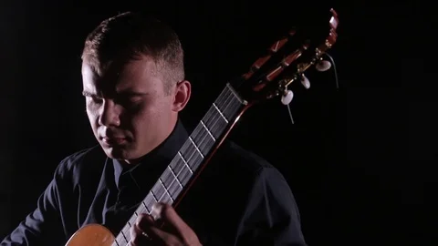 Man plays the classical guitar on a black background,close-up face,isolated 스톡 동영상 121583901