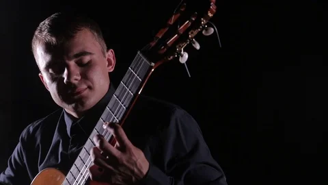 Man plays the classical guitar on a black background,close-up face,isolated Stock Footage 121583920