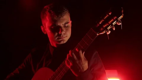 Man plays the classical guitar on a black background, close-up face, isolated 库存影片 121584160