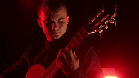 Man plays the classical guitar on a black background, close-up face, isolated 動画素材 121584205