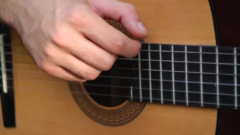 Man plays a classical guitar while sitting at home 스톡 동영상 138293822