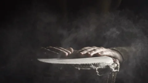 Man plays djembe drum covered with powder in the darkness, front view, slowmo Stock Footage 114063391