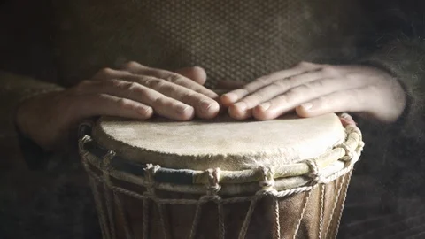 Man plays the djembe drum covered with powder on the dark background, front view Stock Footage 114063697
