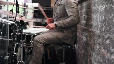 A man plays a drum kit at a party in a clipped suit Stock Footage 157385215
