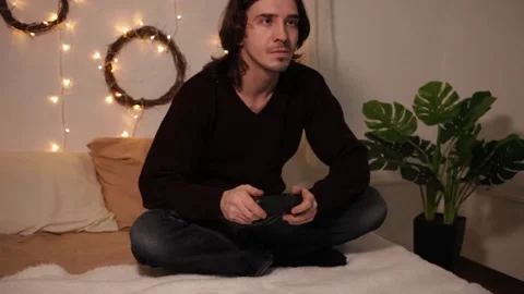 A man plays a game console with a joystick. Violent emotions during the game Video stock 146449621