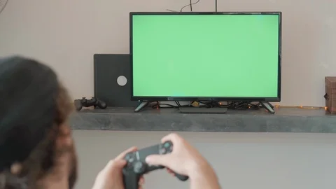 Man plays with a game controller whiile siting on the couch at home Stock Footage 109042091