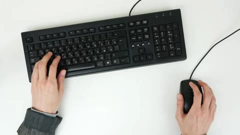 A man plays a game on the keyboard and mouse on a white table. Top view Stock Footage 101839706