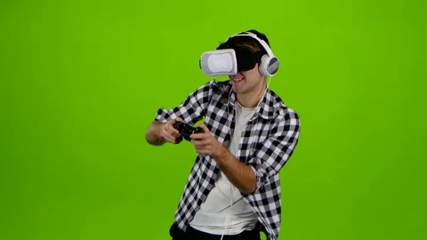 Man plays on gamepad with headphones and in vr glasses Stock Footage