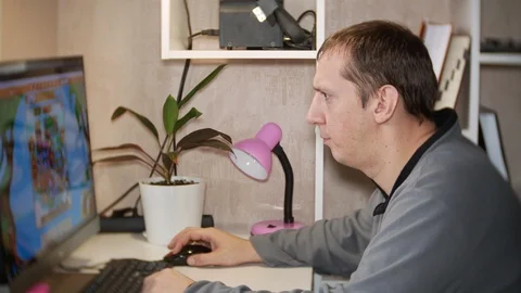 The man plays games for the computer at home. Stock-Footage 121683587