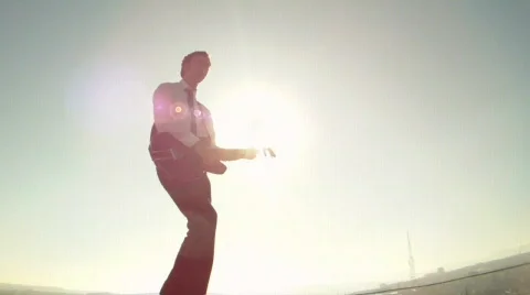 Man plays the guitar on the background of the sun Stock Footage 690169