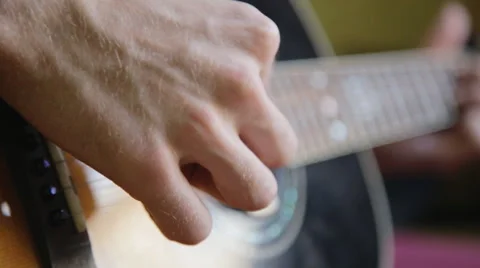 A man plays the guitar close up while sitting at a window in the apartment Stockbeeldmateriaal 64903904