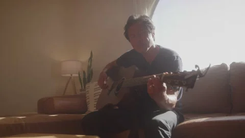 Man Plays Guitar on Couch Stock Footage 208782155