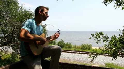 Man Plays Guitar Overlooking Train Tracks Stock Footage 11805841