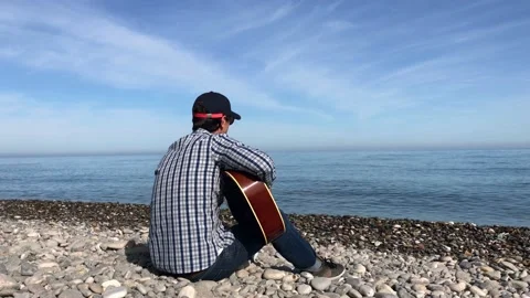 Man Plays on the Guitar at the Sea. Stock Footage 131071953