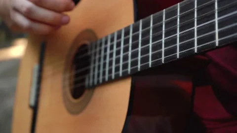 Man plays a guitar while sitting on the street Stockbeeldmateriaal 155492983