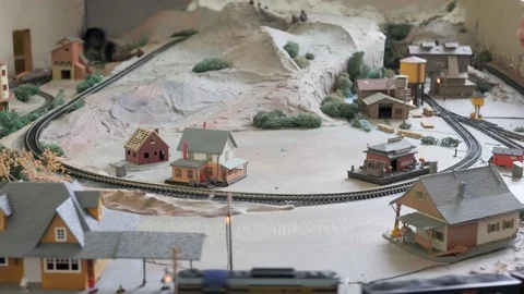 A man plays with his cool replica model train set and buildings Stock Footage 72195955