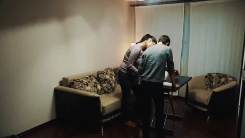 Man plays joke friends couple, pointing gun at them in living room Stock Footage