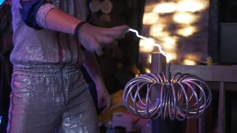 A man plays with lightning. Lord of the current. Tesla mini tower. Of the metal Stock Footage 154327717