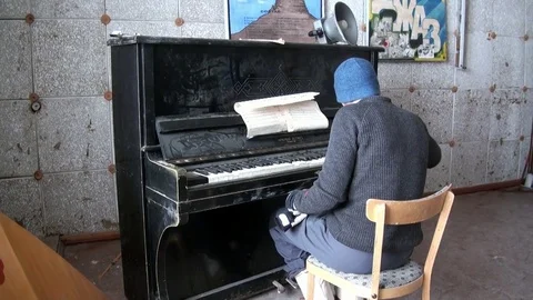 Man plays the old broken musical instruments piano in Pyramiden. Stock Footage 81761884