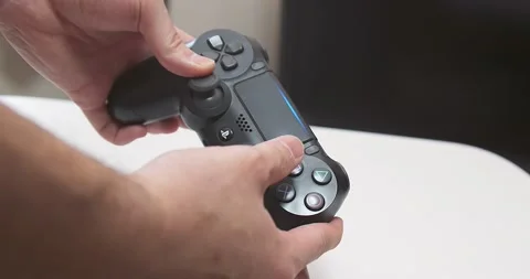 Man plays PlayStation 4 (PS4) by using The DualShock 4 controller Stock Footage 156644232