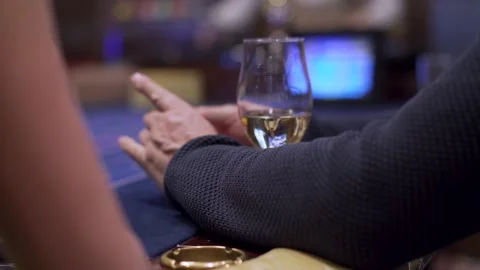 Man plays roulette, close-up of hands and a glass of wine Stock Footage 130243575