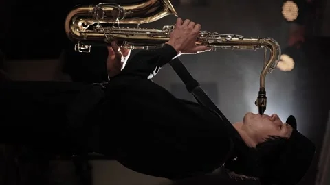 Man plays saxophone. Side view of saxophonist enthusiastically playing melody Видео 248213730