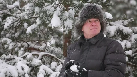 A man plays snowballs in a snowfall Stock Footage 167298399