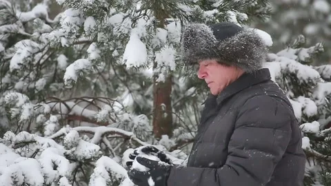 A man plays snowballs in a snowfall Stock Footage 167396478