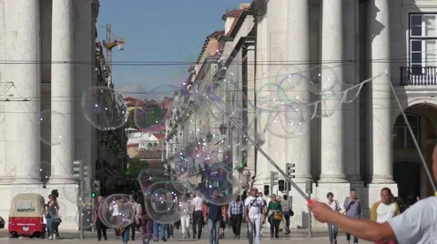 A man plays with soap bubbles near Famous arch at the Praca do Comercio Видео 67893129