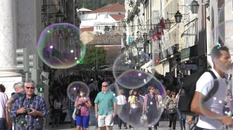 A man plays with soap bubbles near Famous arch at the Praca do Comercio Видео 67893655