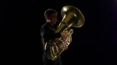 Man Plays on the Tuba Slow Melody. White Studio Background, People