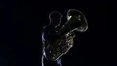 Man Plays on the Tuba Slow Melody. White Studio Background, People
